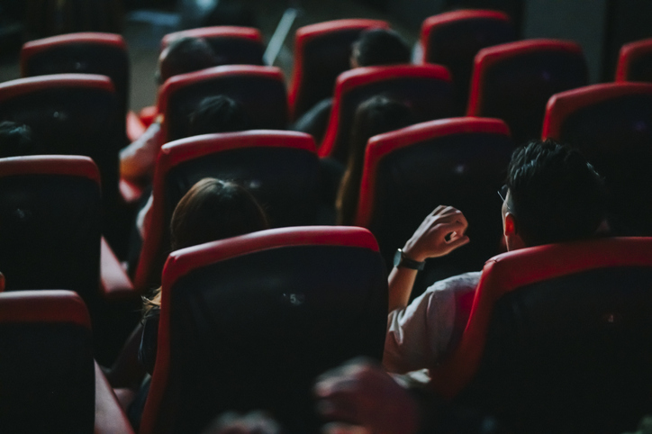rear view asian chinese group of audience watching 3D movie in cinema enjoying the show with 3D glasses screaming excitement