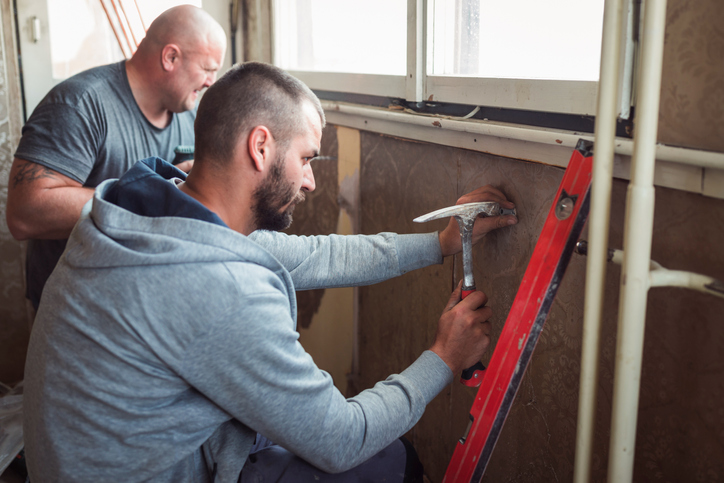 Plumber installing radiator mounting bracket