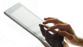 Person's hands holding tablet with touch screen. Empty white copy space background.