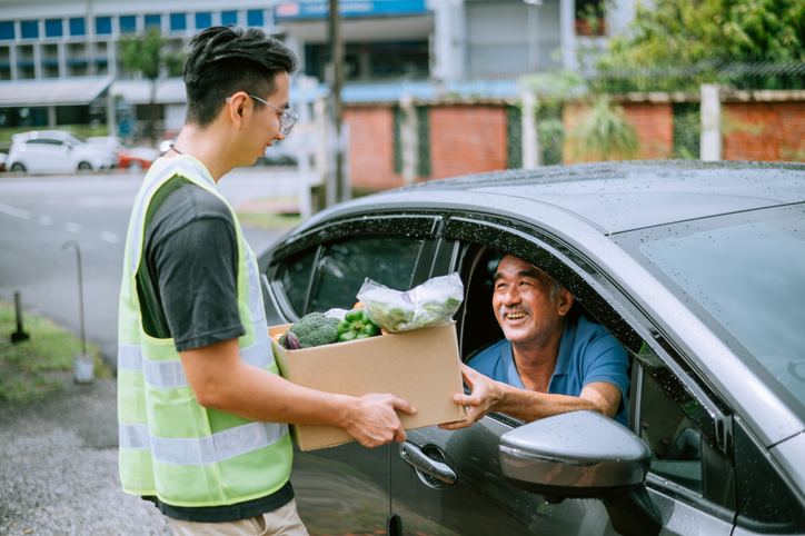 An Asian chinese man receive food from Volunteer