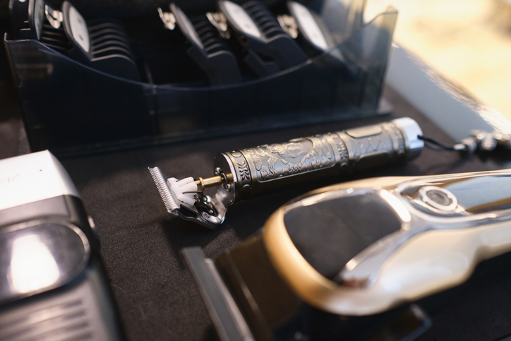 Selective focus shot of a carved metal grooming trimmer in grooming set for a professional barbers