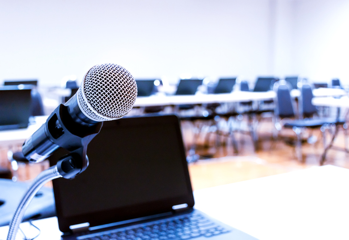 Close up microphone with laptop on table background in seminar room