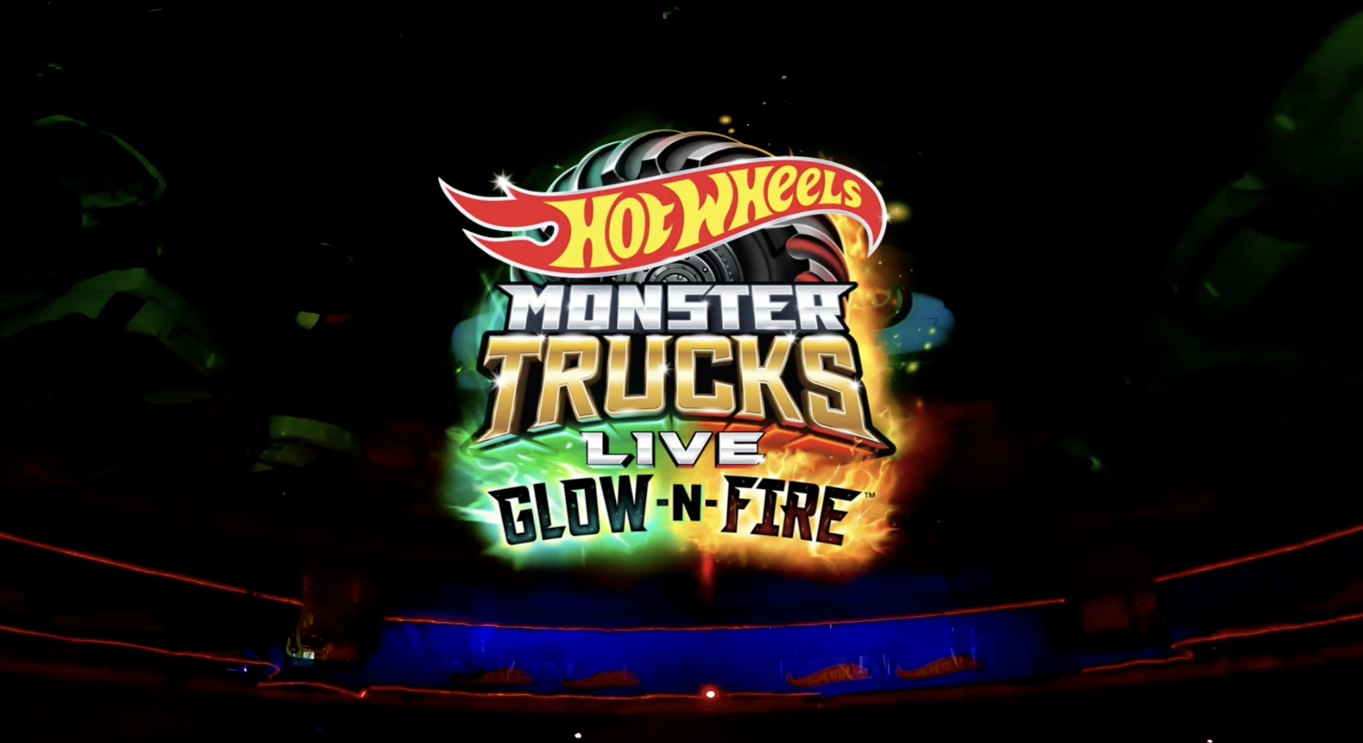 Hot Wheels Monster Trucks Live Glow-n-Fire logo on a dark background with colorful lights and explosions.
