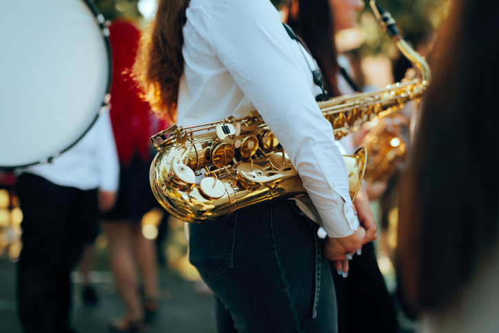 Female Musician Holding Golden Saxophone During Outdoor Performance