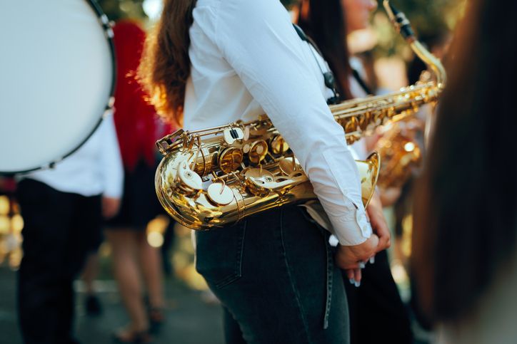 Female Musician Holding Golden Saxophone During Outdoor Performance