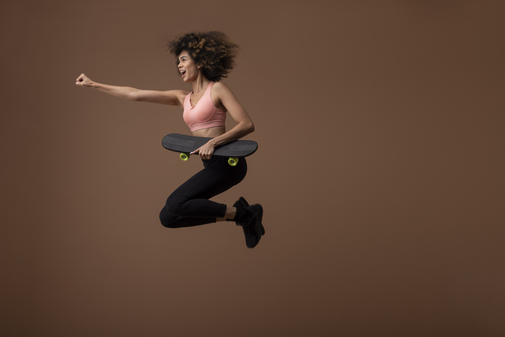 Woman jumping with skateboard