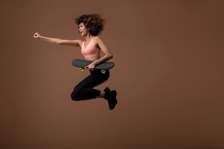 Woman jumping with skateboard