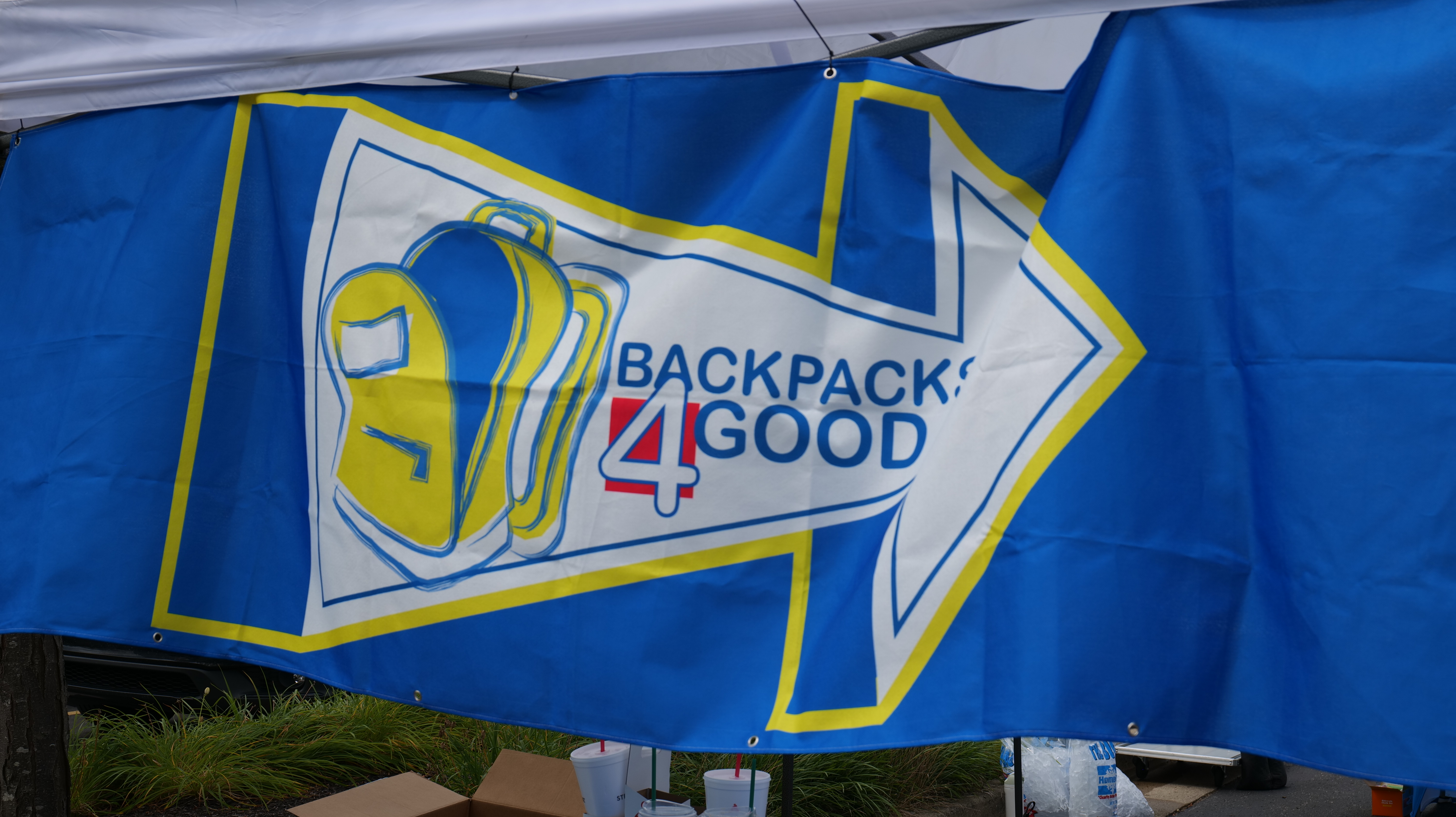 Blue and yellow banner with "Backpack 4 Good" logo and arrow