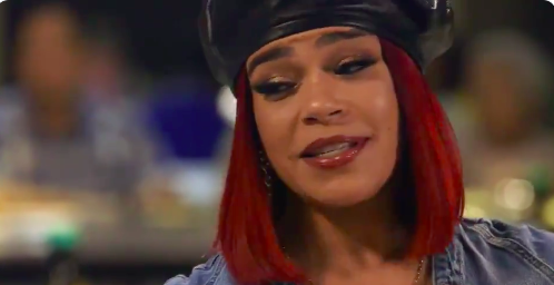 A woman with long, vibrant red hair smiling at the camera.