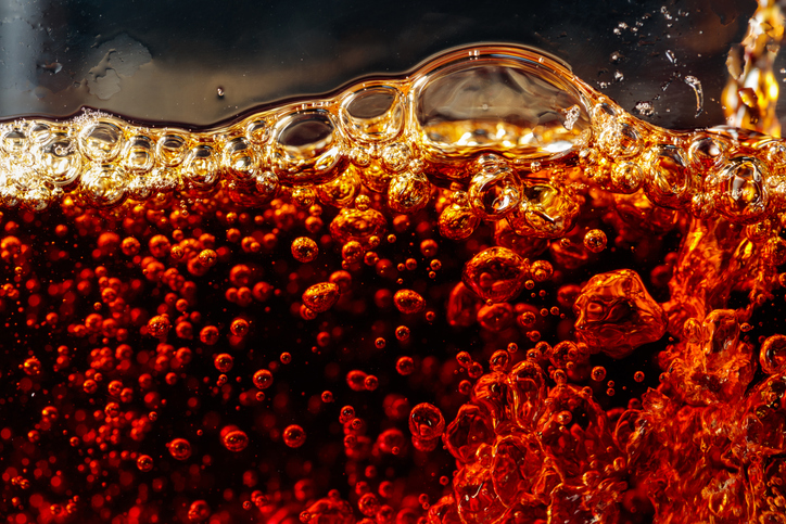 Carbonated drink is poured into a glass.