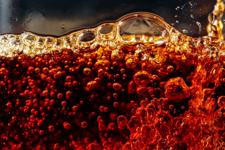 Carbonated drink is poured into a glass.